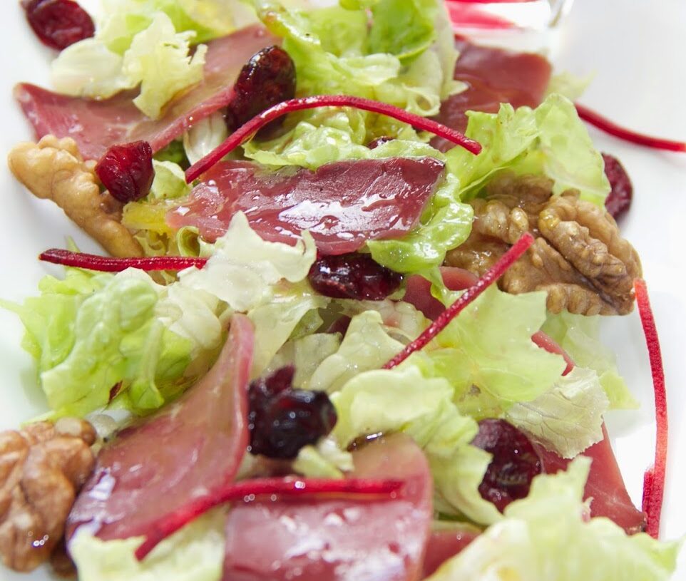 Salade de magrets de canard aux cranberries, cerneaux de noix et huile d’ olive à la cerise.